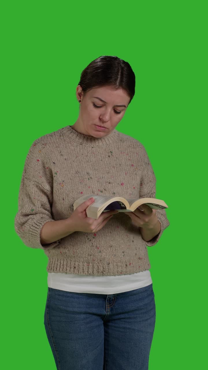 Video im Hochformat: Junge Person mit Action-Buch in der Frontansicht im Studio beim Lesen