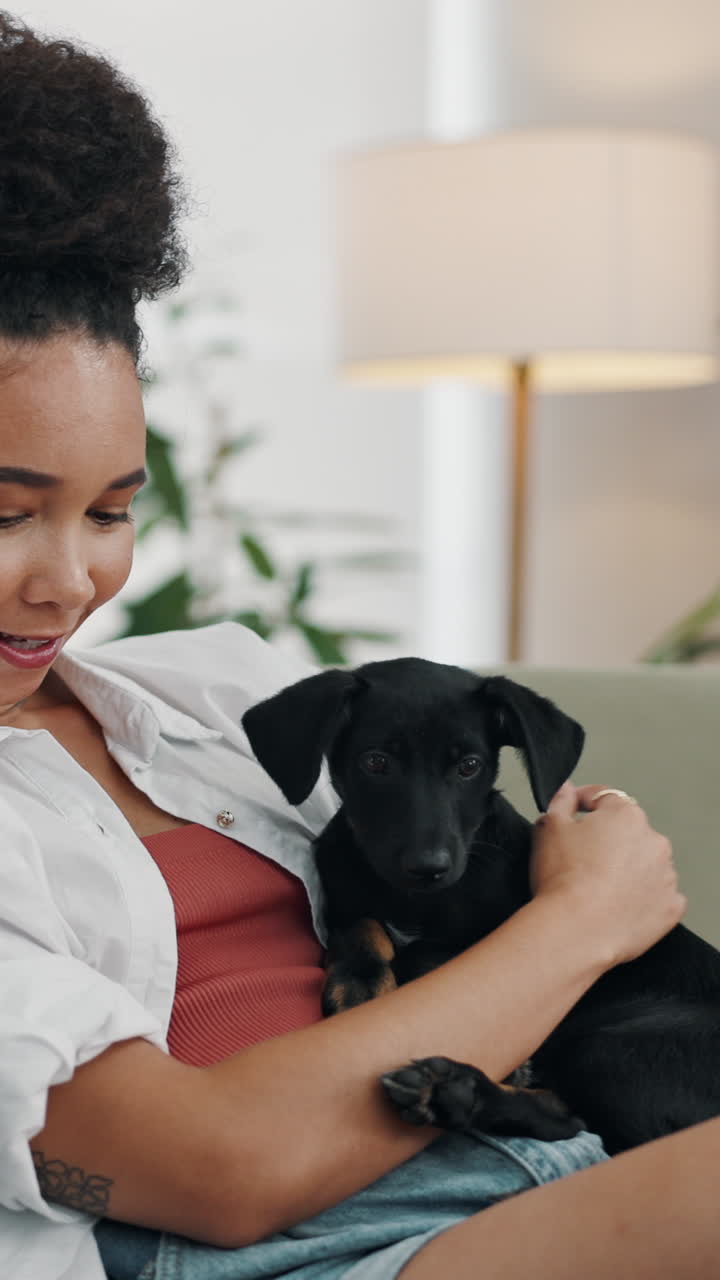 Young Woman Cuddling and Smiling with Her Puppy at Home