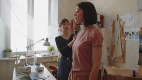 modista tomando medidas del cuerpo de una cliente femenina