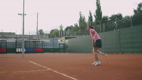 young caucasian woman playing tennis on a court returning a ball in slow motion