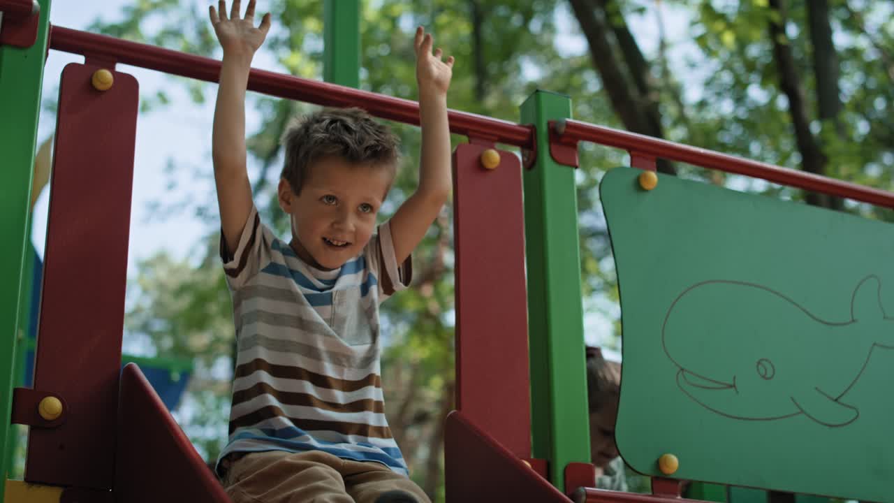 un chico caucásico jugando al deslizamiento en un día de verano.