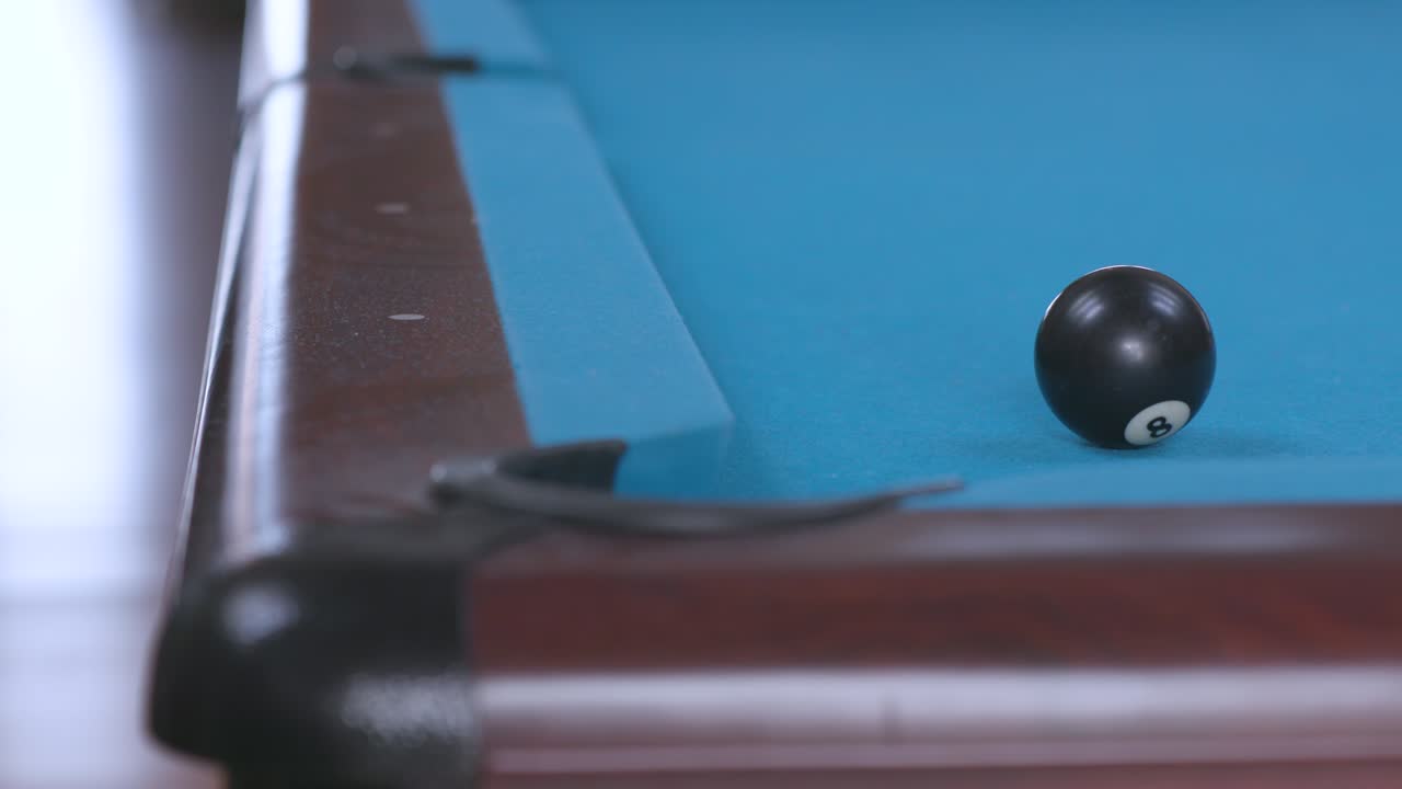 hundimiento de la pelota 8 en el bolsillo de la esquina en la mesa de billar azul