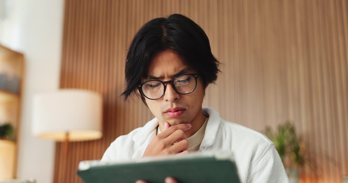 Young Man Using Tablet and Thinking in Modern Home Office