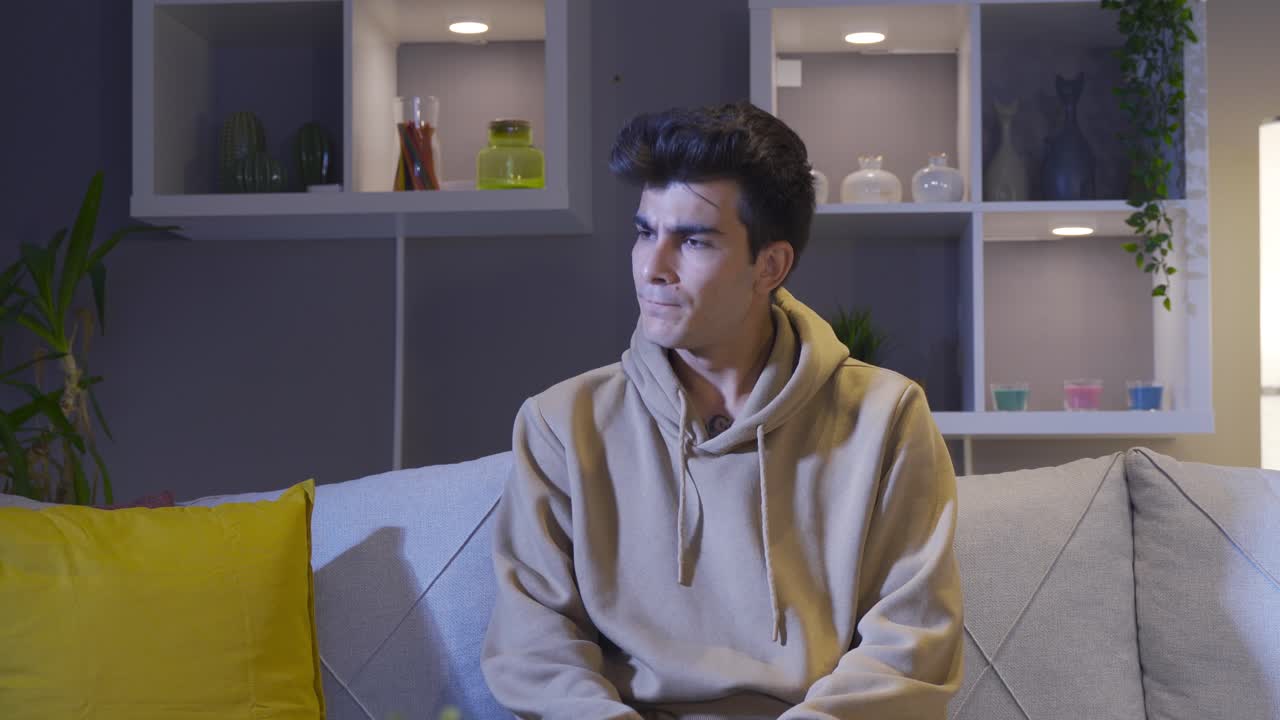 밤에 집에 앉아 있는 좌절하고 스트레스를 받는 남자.