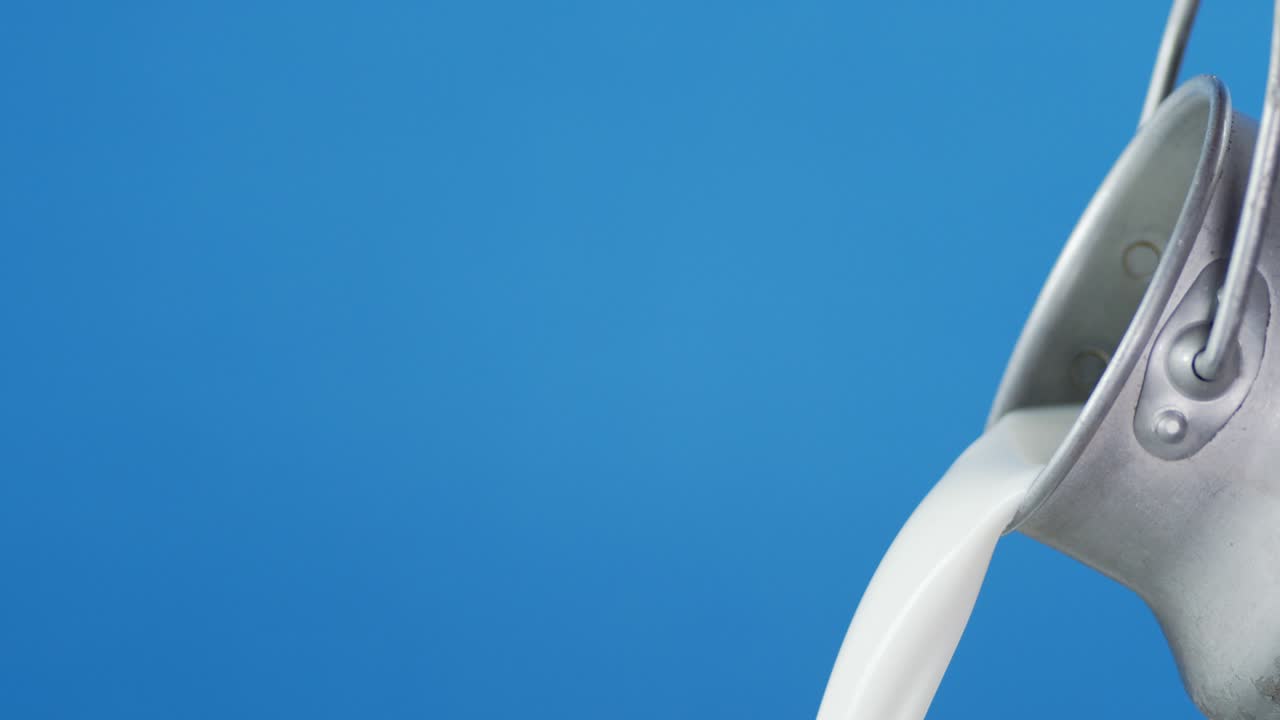 Fresh milk pouring from a can.