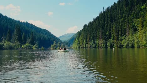 Family-Paddling-Canoe-On-River-Between-Mountains