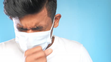 man coughing and wearing a mask