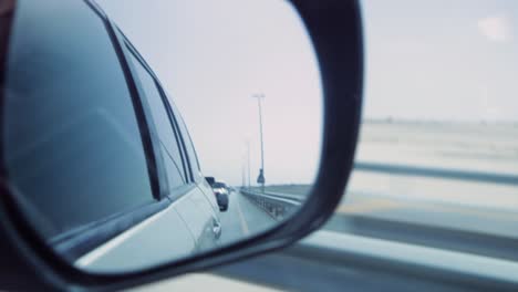 car driving on highway, view from side mirror