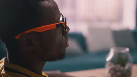 man wearing glasses and a yellow shirt, profile view