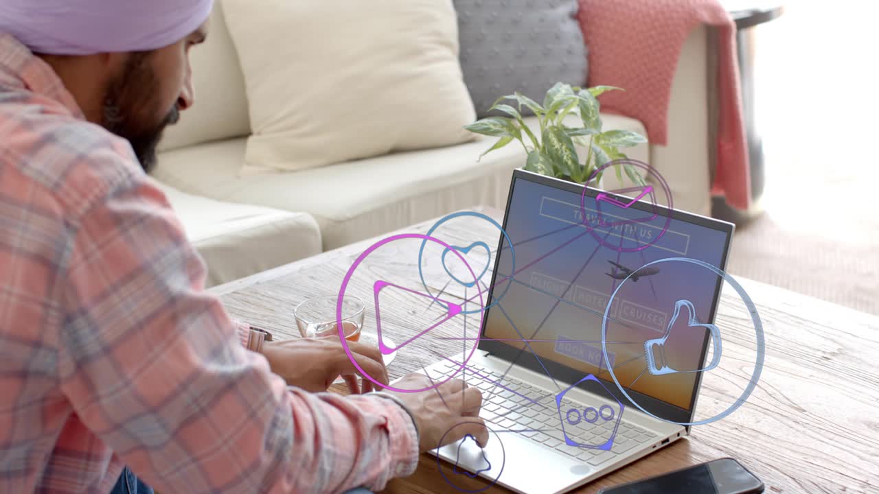 Man typing on travel site at table, generating social icons overlaying laptop, phone, planning trip