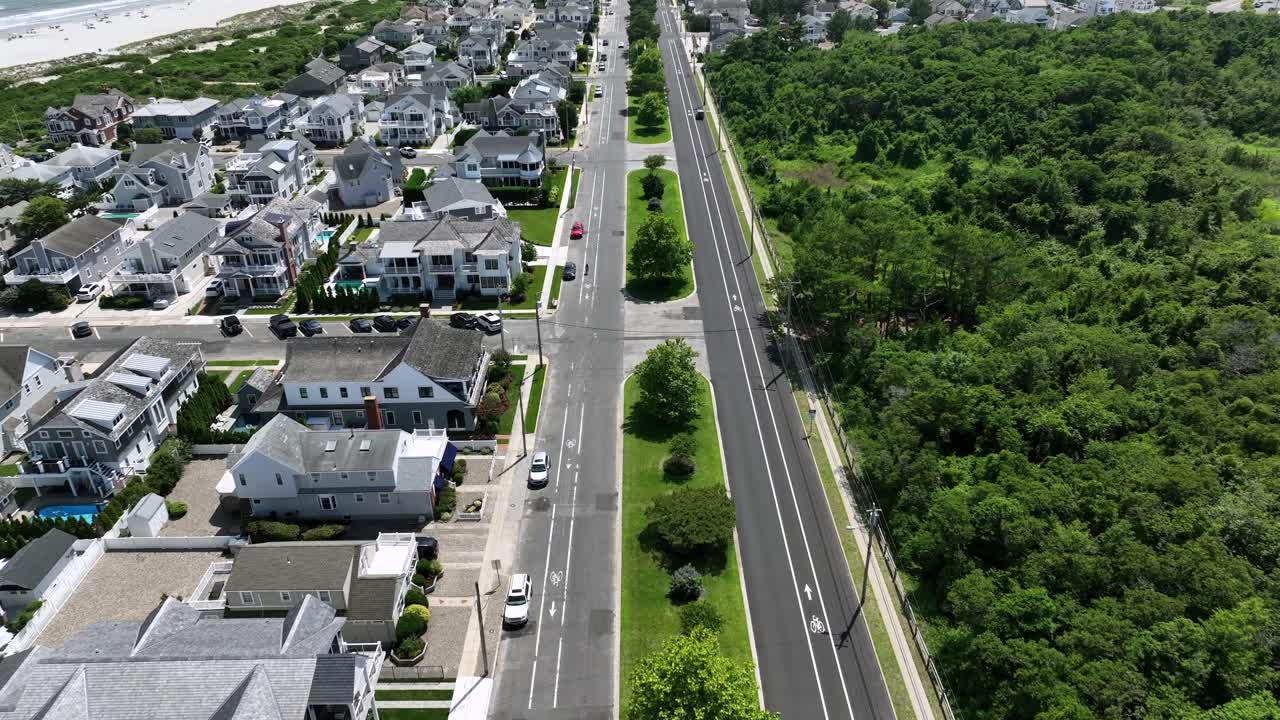 Main Street in stone harbor beach during sunny day. Aerial Birds Eye shot. Sunny day in summer. Luxury and noble villas and mansion in New Jersey, America. Green forest trees in district