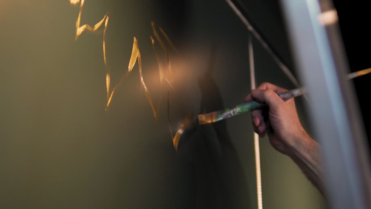 cámara lenta de la mano del hombre que dibuja en la pared con un cepillo