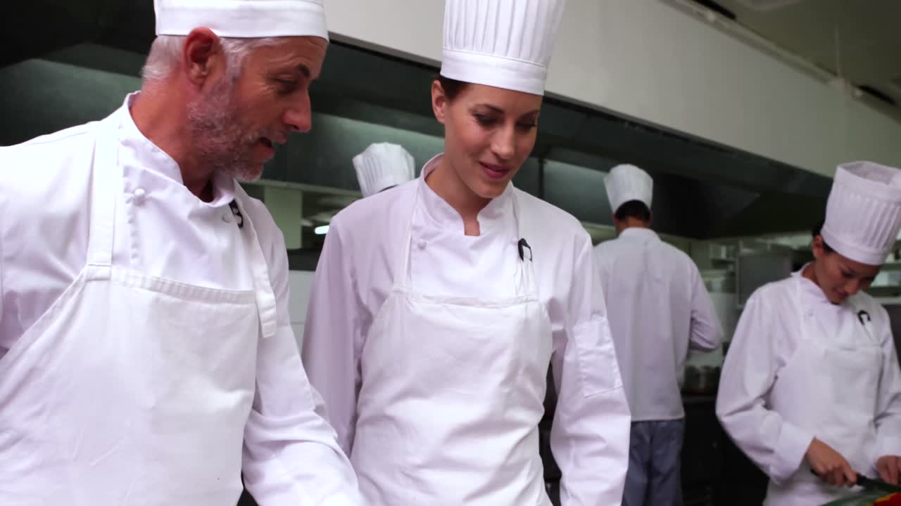 jefe de cocina mostrando a otro cómo hacer pizza
