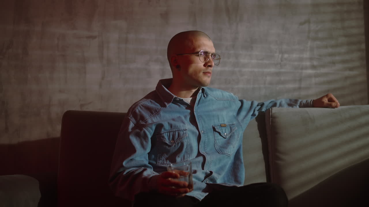 Man Sitting on Couch Drinking