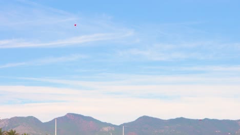 Fallschirmjäger-Aus-Der-Ferne-Mit-Den-Castellon-Bergen-Im-Hintergrund,-Der-In-Benicassim-Landet