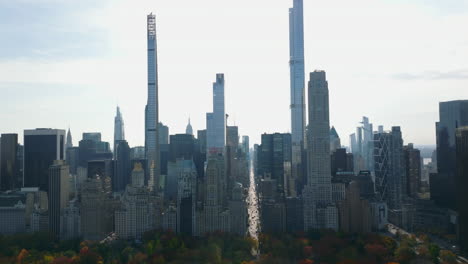 Tall-modern-skyscrapers-and-large-historic-buildings-on-south-end-of-Central-park.-View-against-bright-sky.-Manhattan,-New-York-City,-USA