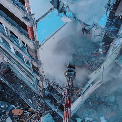 Process of dismantling a structure after an earthquake. Destruction of walls and concrete blocks that were broken by the earthquake. Excavator dismantling high buildings