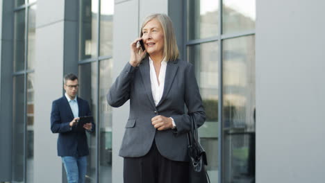 mature businesswoman talking on the phone in the street 1