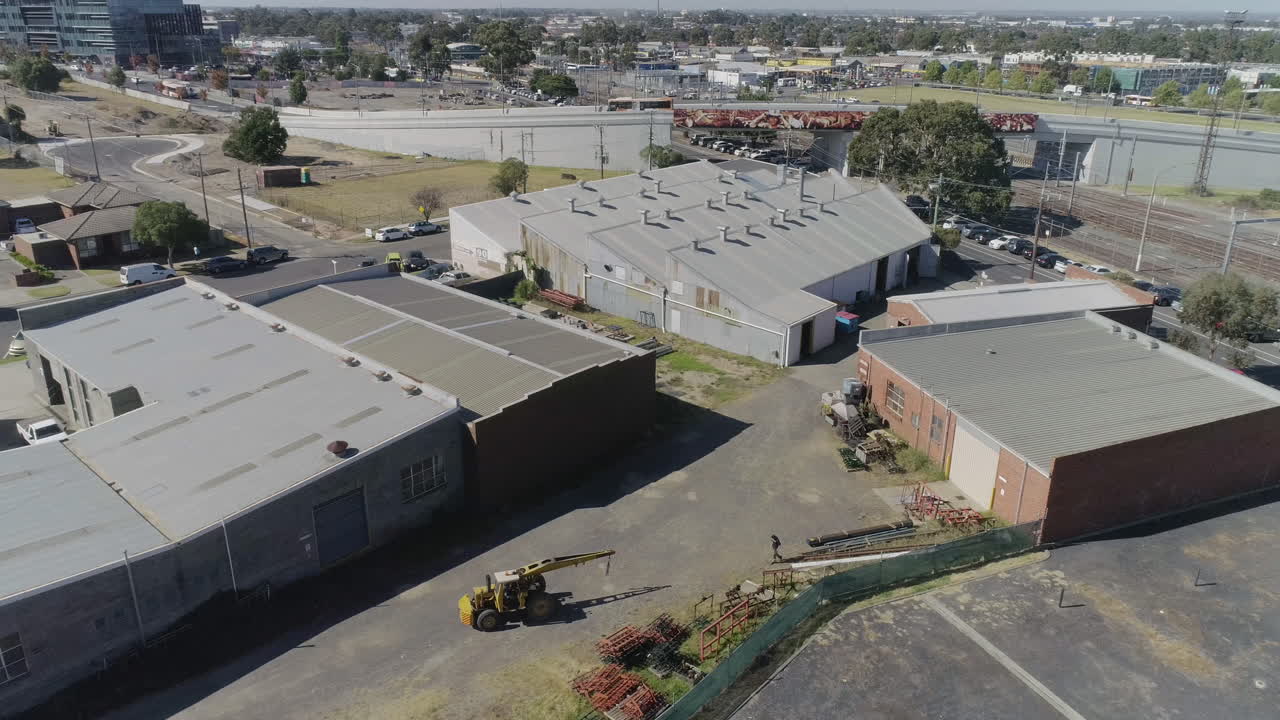 Yellow crane moving and maneuvering into the correct position to relocate heavy metal products