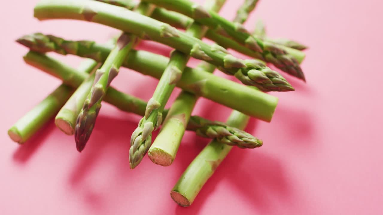 핑크색 배경 위에 신선한 아스파라거스의 클로즈업 비디오