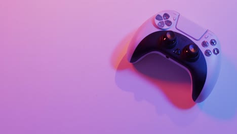 Video-of-close-up-of-video-game-pad-controller-with-copy-space-on-neon-background