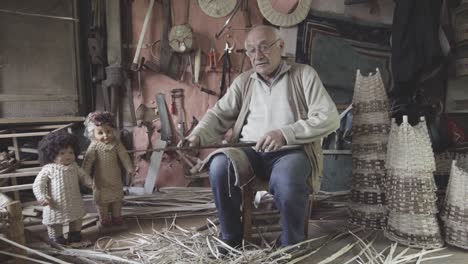 basket weaving master shapes wooden sticks. 4k footage. craft concept.