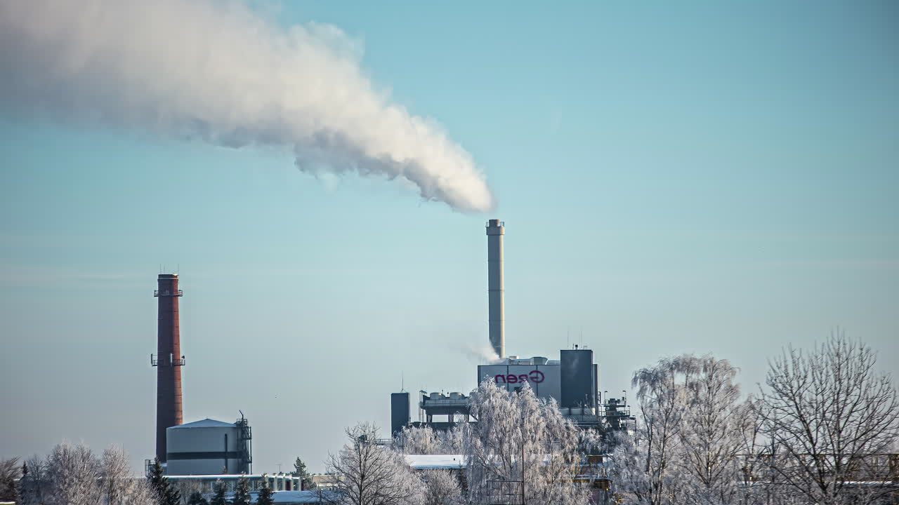 vapore da una ciminiera di fabbrica con la falce di luna crescente debolmente vista attraversare il lasso di tempo del cielo