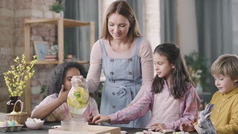 woman serving lemon water to kids