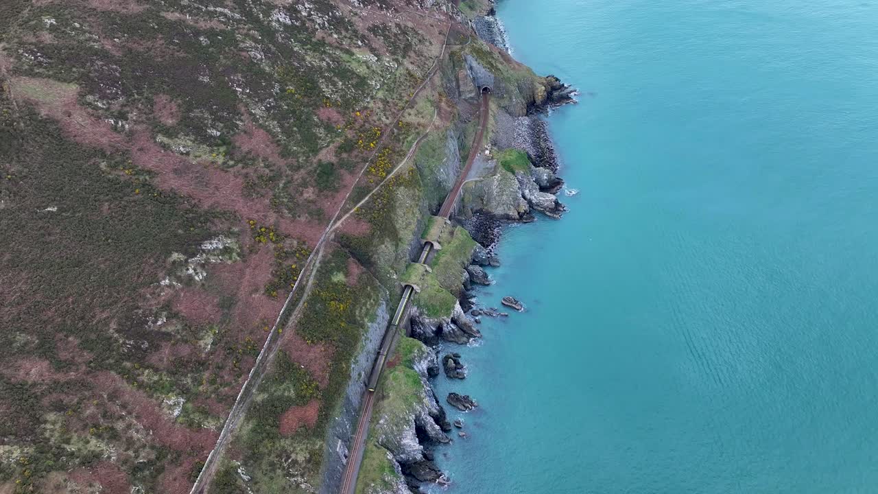 Manzaralı tren rotası, tünellerden ve kayalık kıyıdan geçen tren. Bray'den Greystones'a, İrlanda. Havadan.