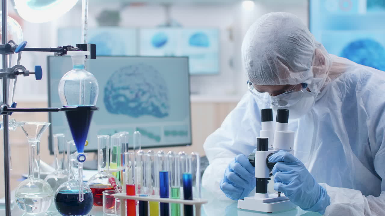 Científico trabajando con microscopio en laboratorio.