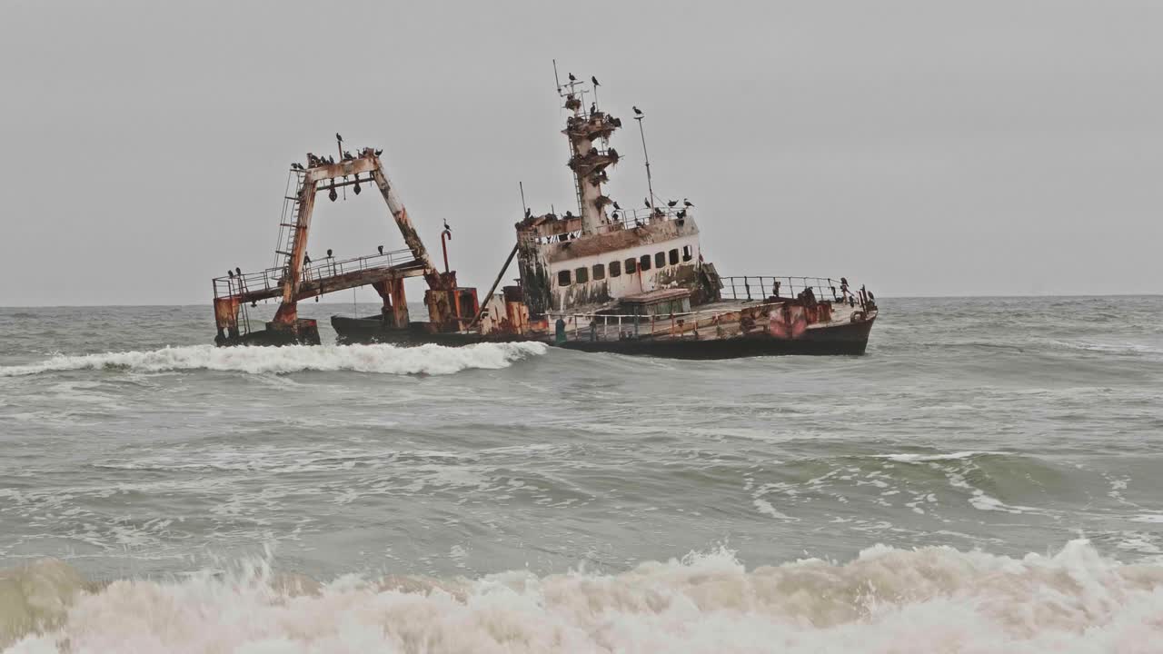 Waves rolling in past Zeila shipwreck along Namibia Skeleton Coast, Wide Shot