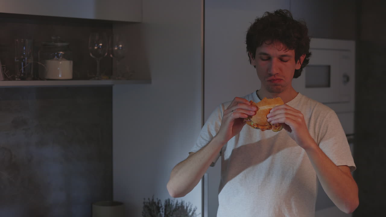 Young man having a late night snack in the kitchen