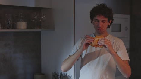 young man having a late night snack in the kitchen