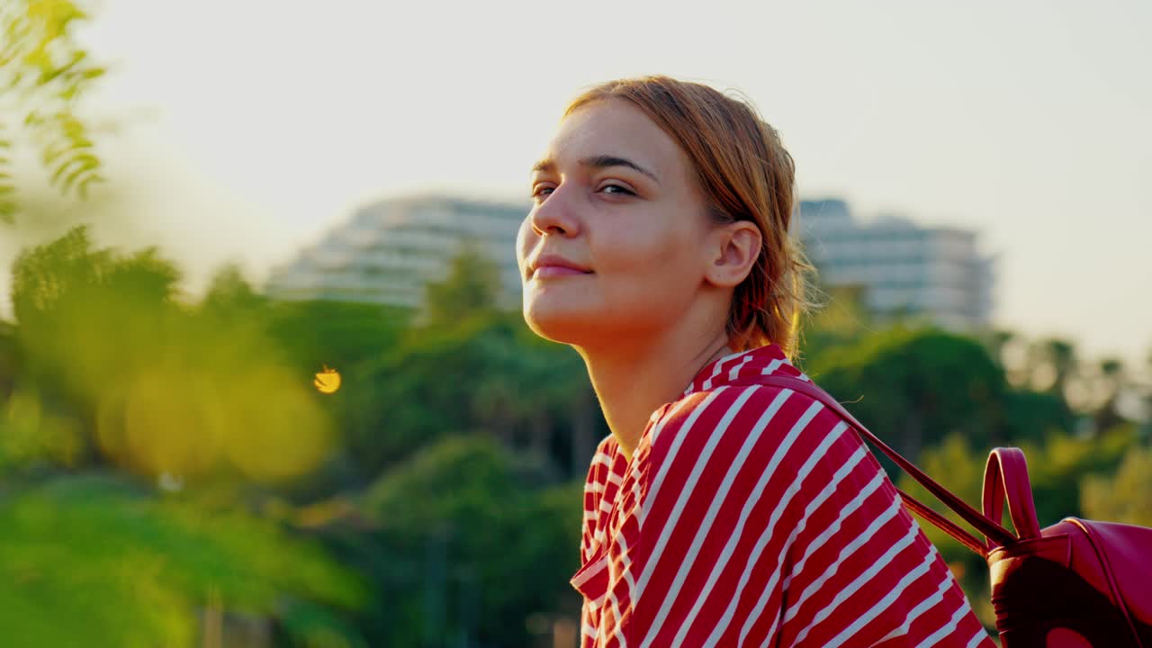 Ohromující 4K video bílé rusovlasé dívky s batohem, která stojí a dívá se na krásný výhled