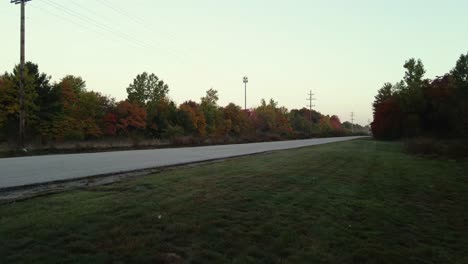 Deep-fall-colors-filling-the-trees-as-a-drone-lands-nearby-in-reverse-descent