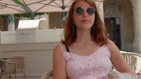 chica con gafas de sol comiendo un pastel de cannoli en caffe cordina en valletta, malta