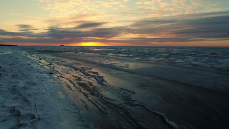 Un-Vuelo-Rápido-Sobre-Una-Playa-De-Invierno-Y-Un-Mar-Helado-Al-Atardecer