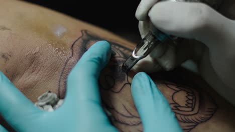 close-up of a tattoo artist inking a tiger design on an arm