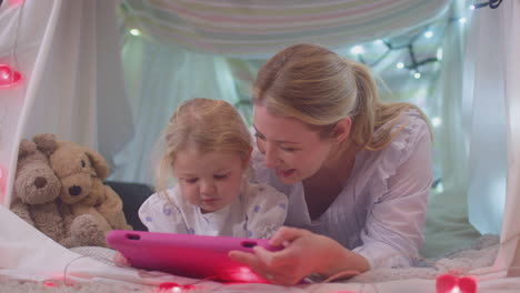 Madre-E-Hija-Pequeña-Con-Tableta-Digital-En-Un-Campamento-Casero-En-El-Dormitorio-De-Un-Niño-En-Casa---Filmadas-En-Cámara-Lenta