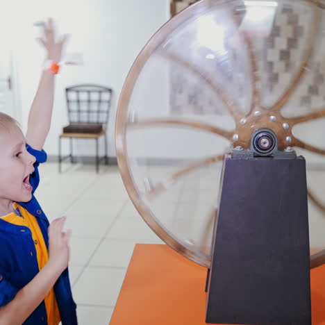 the boy examines the perpetual motion machine. science exhibition museum
