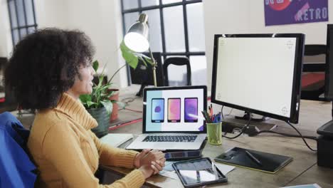 African-american-female-designer-using-computers-with-copy-space-in-casual-office,-slow-motion