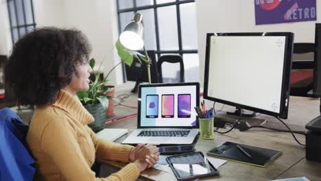 diseñadora afroamericana que usa computadoras con espacio de copia en una oficina casual, cámara lenta