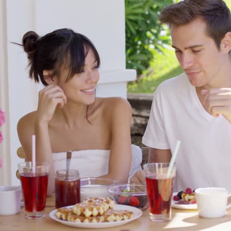 attractive couple enjoying breakfast outdoors