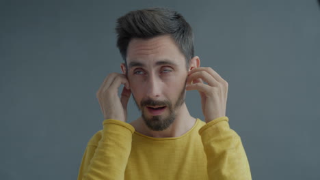man with headphones, expressing confusion or displeasure