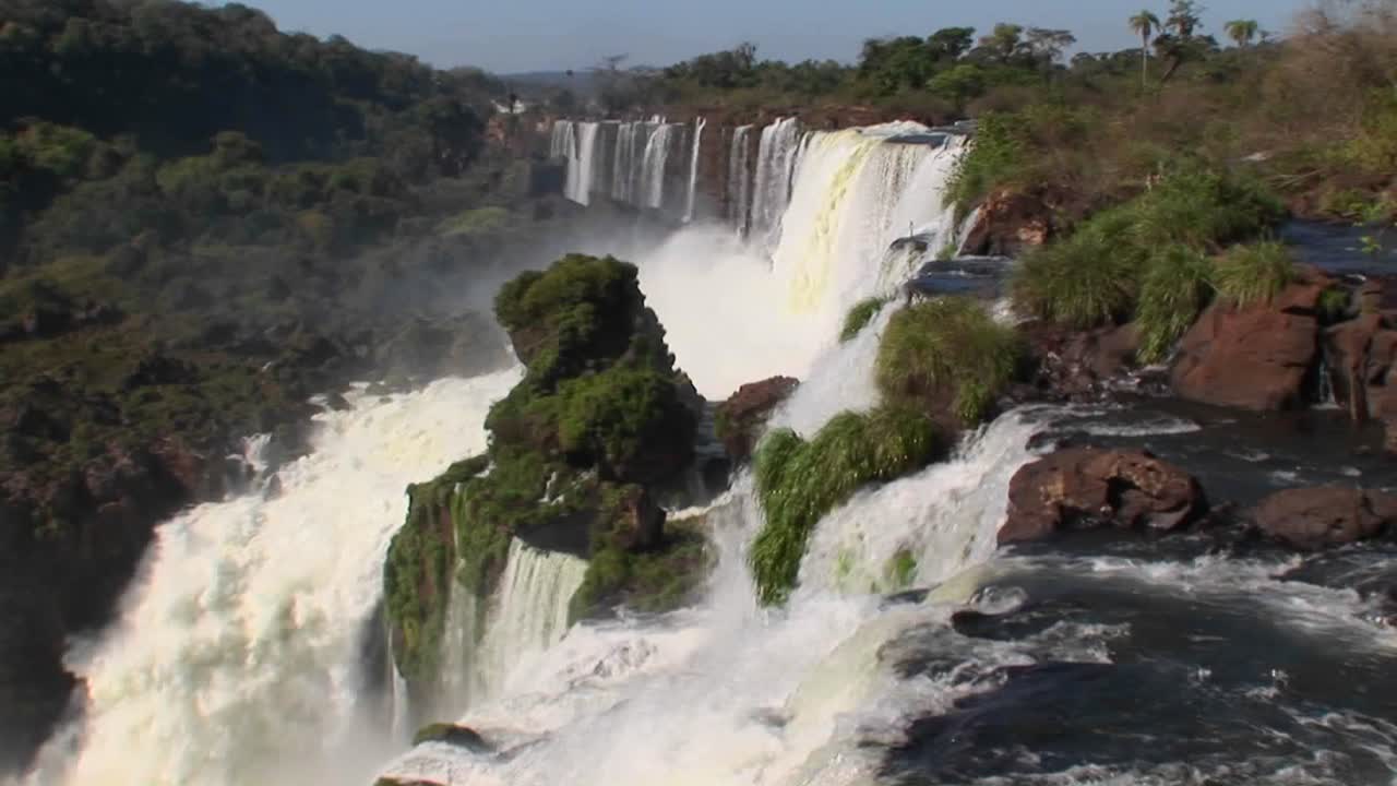 las cataratas del iguacu fluyen fuera de la jungla con un arco iris en primer plano 1
