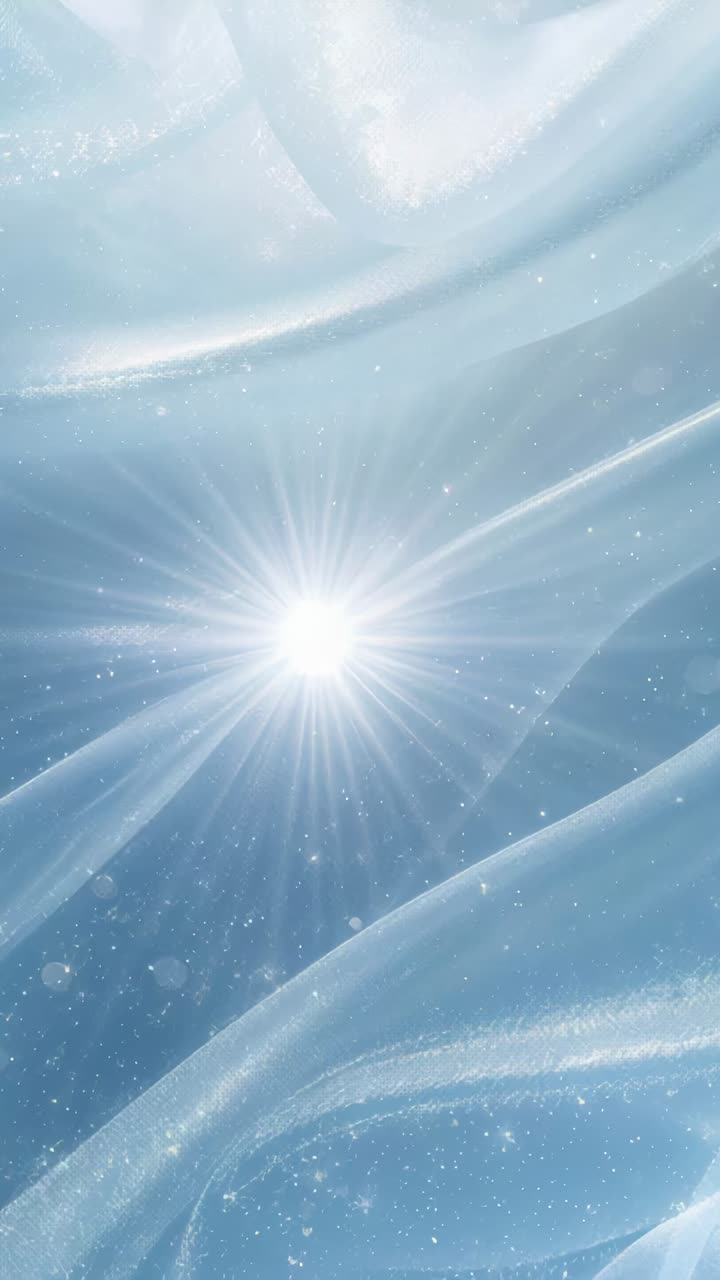 Vertical video: Bursting white starburst flare pulsing over blue sheer folds with drifting sparkles