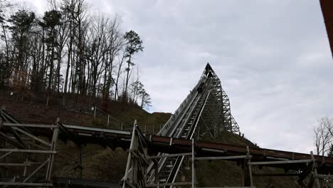 riders experience the thrill of acceleration while being launched on roller coaster up steep hill. amusement park ride with banks, turns, incline and drops. coaster cars speed away from the station.