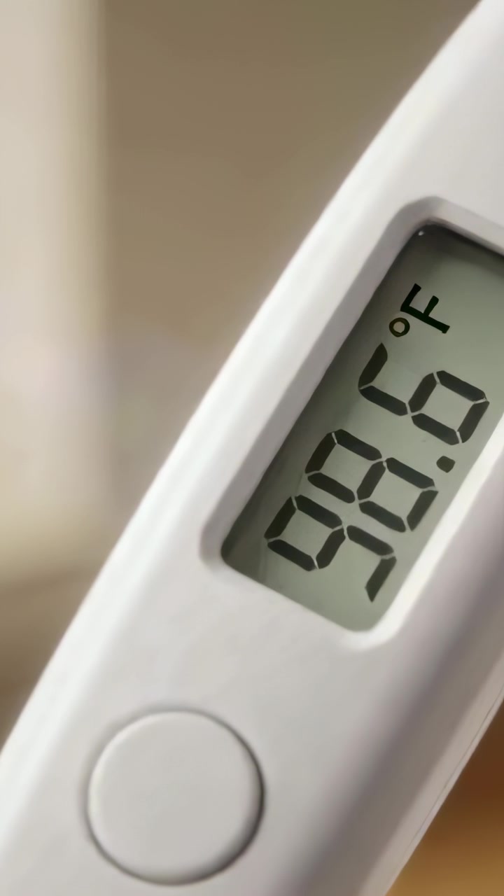 Vertical video: Rotating thermometer displaying 98