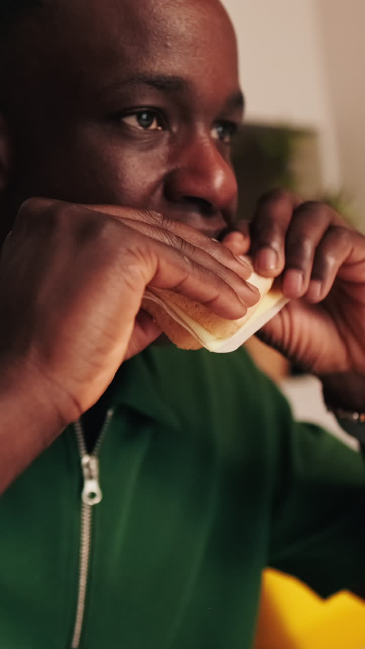 Uomo afroamericano che mangia un panino