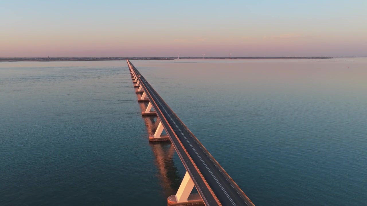 Riprese aeree che mostrano l'infinito Zeelandbrug che attraversa le acque calme dell'estuario dell'Oosterschelde durante un bellissimo tramonto.